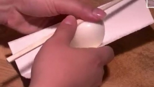 Zawinęła jajko w kawałek kartonowego opakowania i docisnęła patykiem. Gdy zobacz