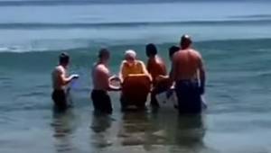 Pięciu mężczyzn otacza umierającego mężczyznę w morzu, chwilę później wszyscy na